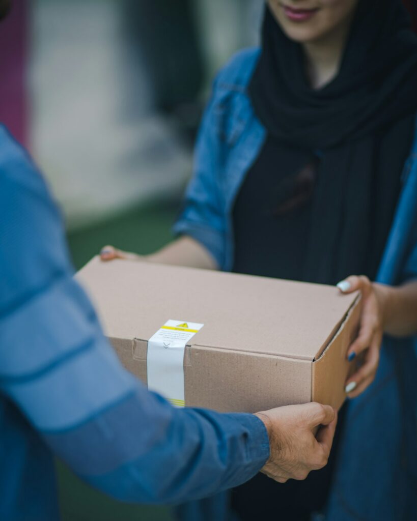 Courier handing over a Qihistore Shop delivery box